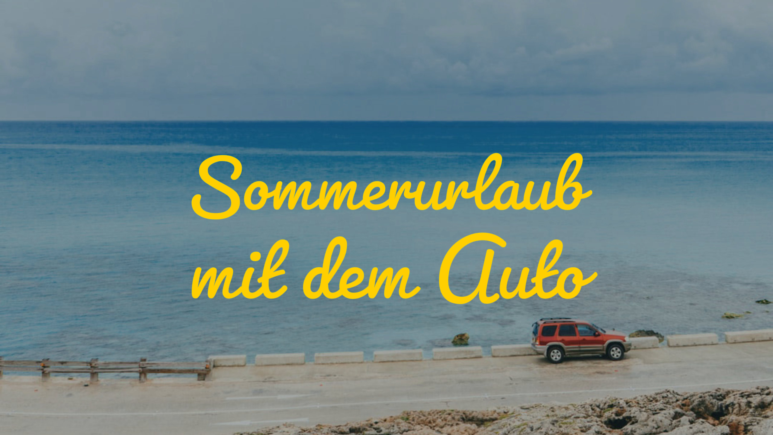 Ein rotes Auto fährt auf einer Landstrasse in der Nähe der Meeresküste